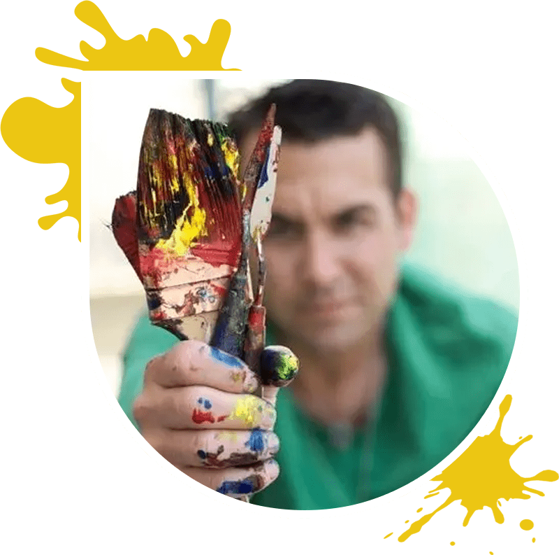 A man holding up an object with paint on it.